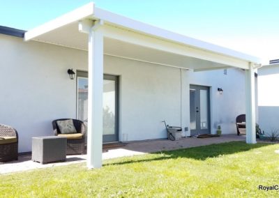 A photograph of a solid Alumawood patio cover installation over a residential backyard, highlighting the complete sun protection and covered outdoor living area it provides.