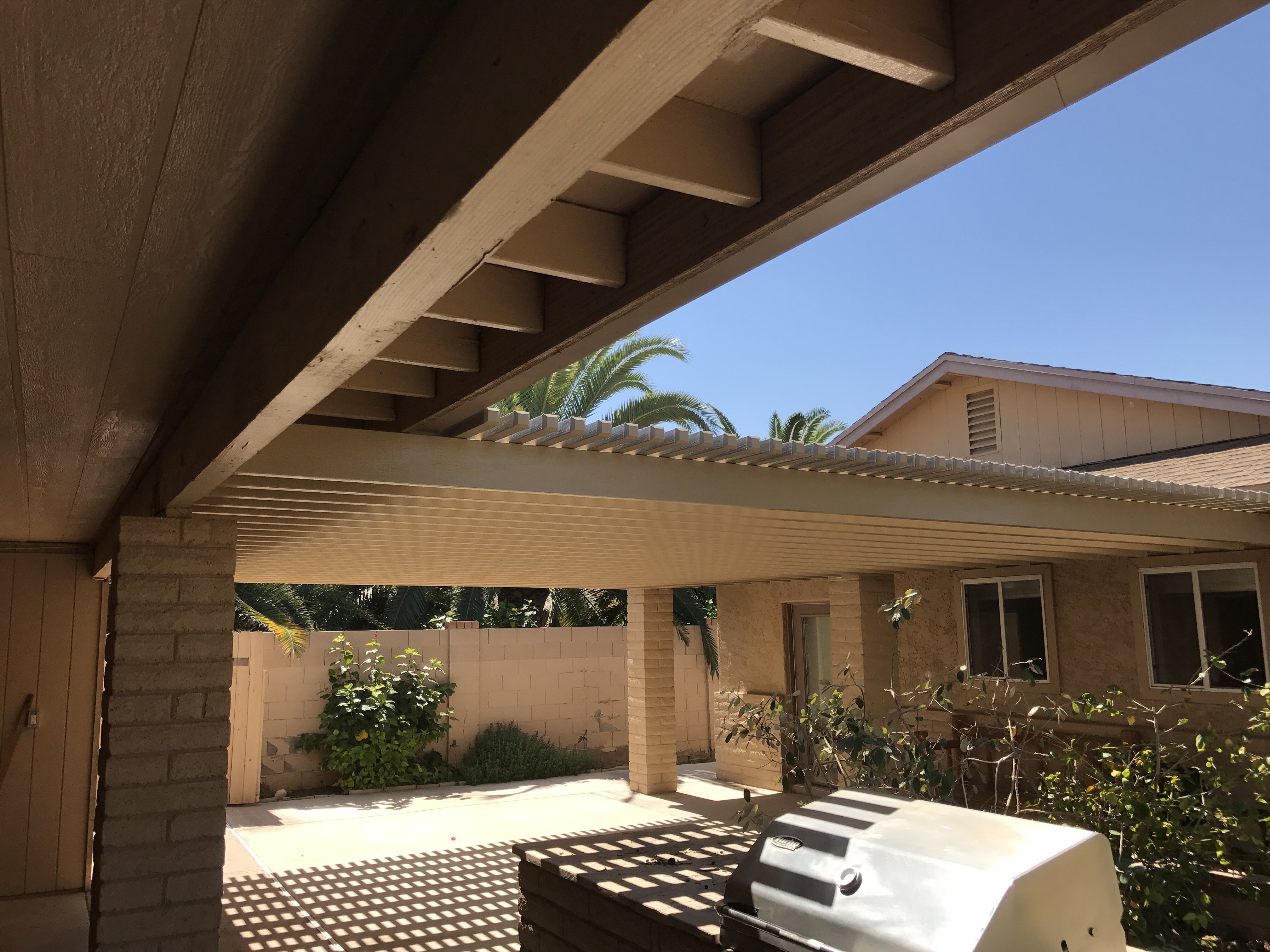 Modern Alumawood patio cover with insulated panels and motorized louver system.