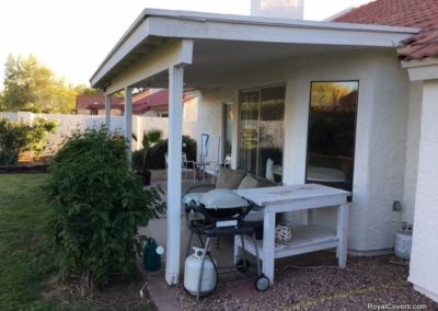 A photograph of a solid Alumawood patio cover installation over a residential backyard, highlighting the complete sun protection and covered outdoor living area it provides.