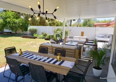A photograph of a solid Alumawood patio cover installation over a residential backyard, highlighting the complete sun protection and covered outdoor living area it provides.