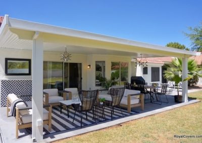 A photograph of a solid Alumawood patio cover installation over a residential backyard, highlighting the complete sun protection and covered outdoor living area it provides.