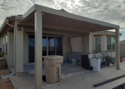 A photograph showcasing an Equinox louvered roof system installed over a residential patio, highlighting the adjustable slats that allow for customizable light and ventilation control in an outdoor living space.
