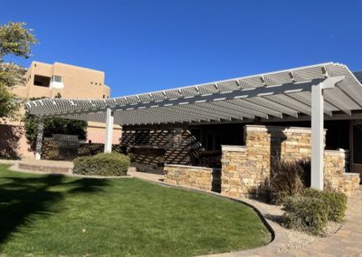 A photograph of a completed patio cover installation, showcasing the structure's clean design and the comfortable shade it provides for an outdoor residential living area.