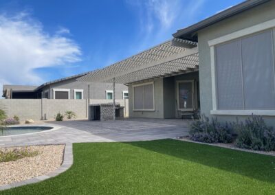 A photograph showing a completed patio cover installation, highlighting its design and the functional shade it provides to a residential backyard area.