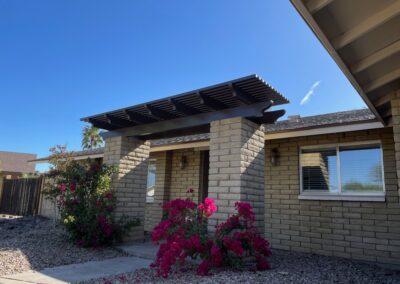 A photograph showing a completed patio cover installation, highlighting its design and the functional shade it provides to a residential backyard area.