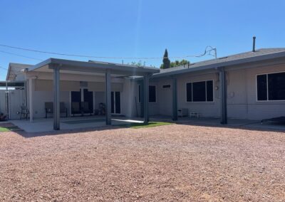 A photograph showing a completed patio cover installation, highlighting its design and the functional shade it provides to a residential backyard area.