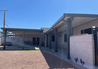 A photograph capturing a finished Alumawood patio cover installation in a residential backyard, highlighting the structure's design and the shade it creates for the outdoor living area.