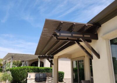 A photograph showing a completed patio cover installation, highlighting its design and the functional shade it provides to a residential backyard area.