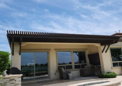 A photograph showing a completed patio cover installation, highlighting its design and the functional shade it provides to a residential backyard area.