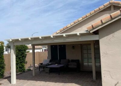 A photograph showing a completed patio cover installation, highlighting its design and the functional shade it provides to a residential backyard area.