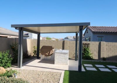 A photograph showing a completed patio cover installation, highlighting its design and the functional shade it provides to a residential backyard area.