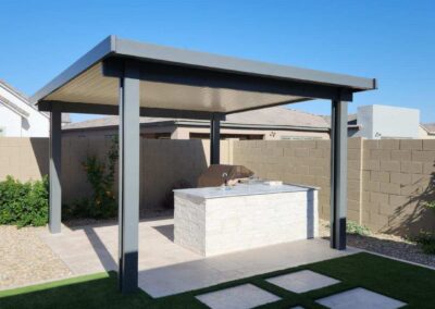 A photograph showing a completed patio cover installation, highlighting its design and the functional shade it provides to a residential backyard area.