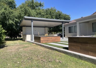 A photograph capturing a finished Alumawood patio cover installation in a residential backyard, highlighting the structure's design and the shade it creates for the outdoor living area.