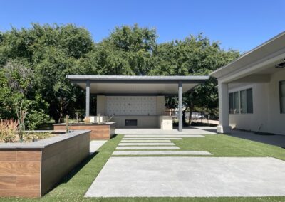 A photograph capturing a finished Alumawood patio cover installation in a residential backyard, highlighting the structure's design and the shade it creates for the outdoor living area.