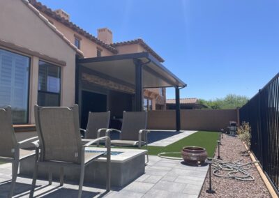 A photograph capturing a finished Alumawood patio cover installation in a residential backyard, highlighting the structure's design and the shade it creates for the outdoor living area.