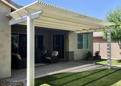 A photograph capturing a finished Alumawood patio cover installation in a residential backyard, highlighting the structure's design and the shade it creates for the outdoor living area.